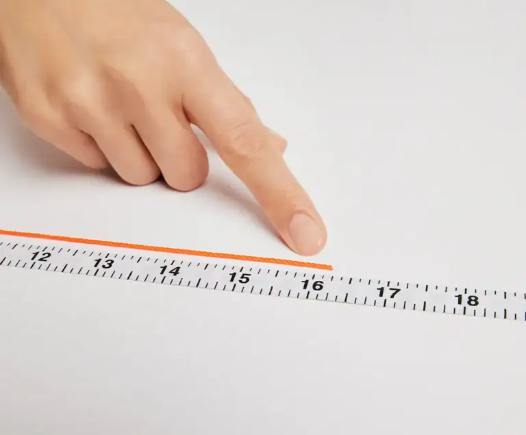 A fingertip marking the point on the string that matches the chosen length on the tape measure